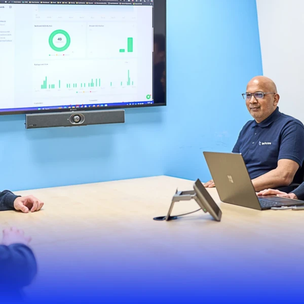 Four men sat around a table discussing charts and statistics on a TV screen.