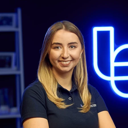 A woman with long blonde hair wearing a navy Techcare polo shirt.