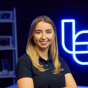 A woman with long blonde hair wearing a navy Techcare polo shirt.